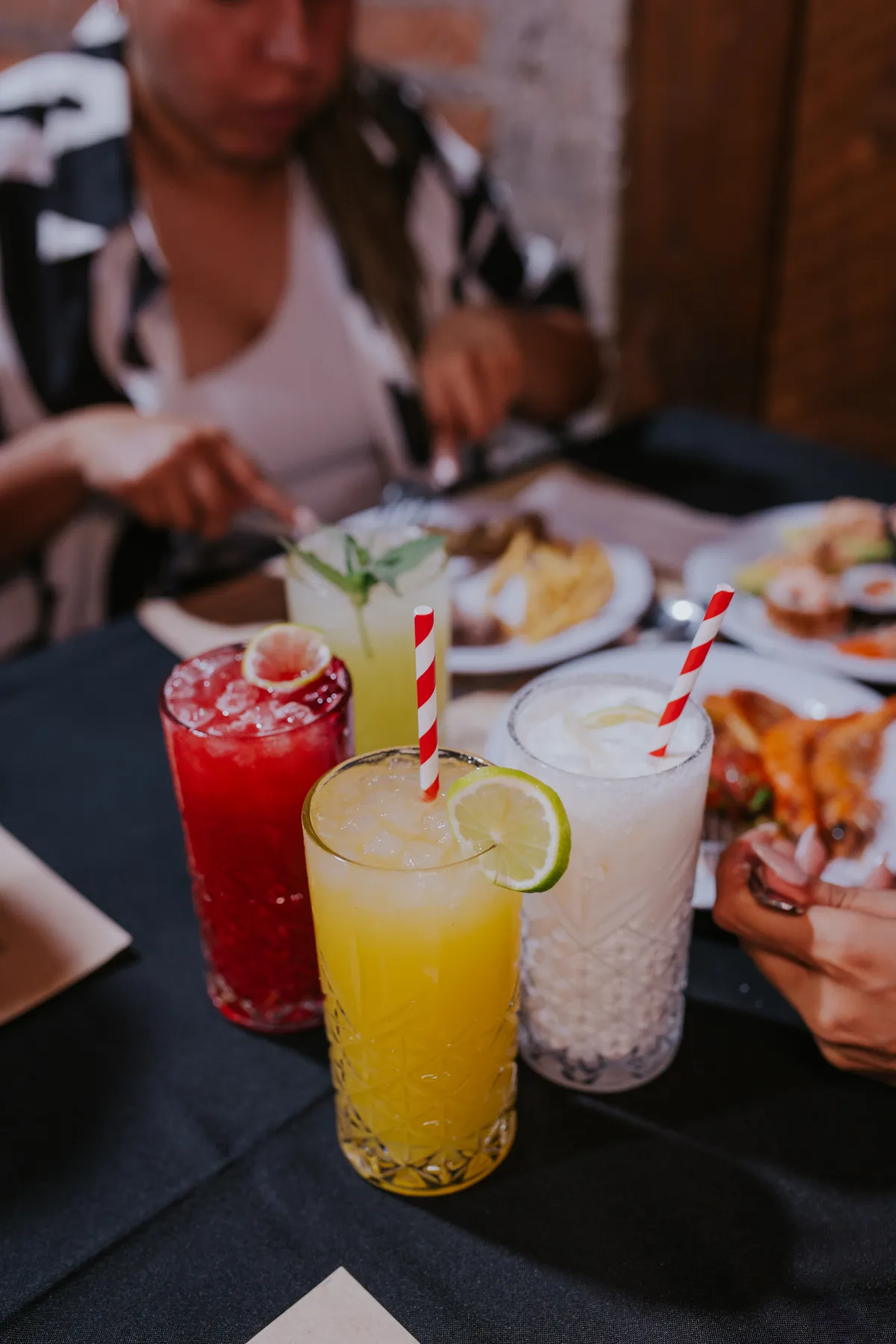 Tres bebidas refrescantes de colores con bombillas y limón